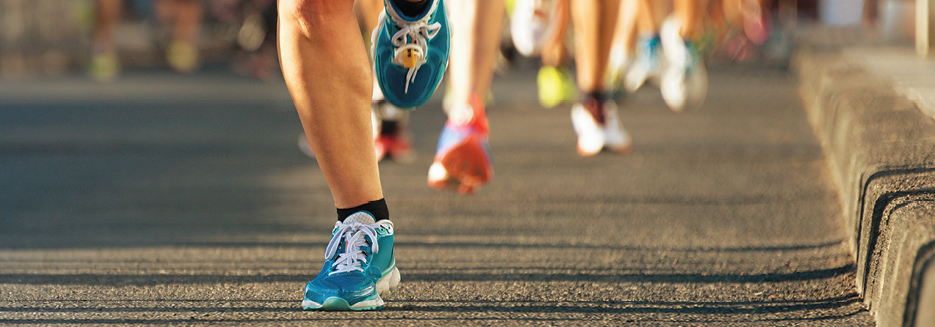 People running a road race in colorful running shoes